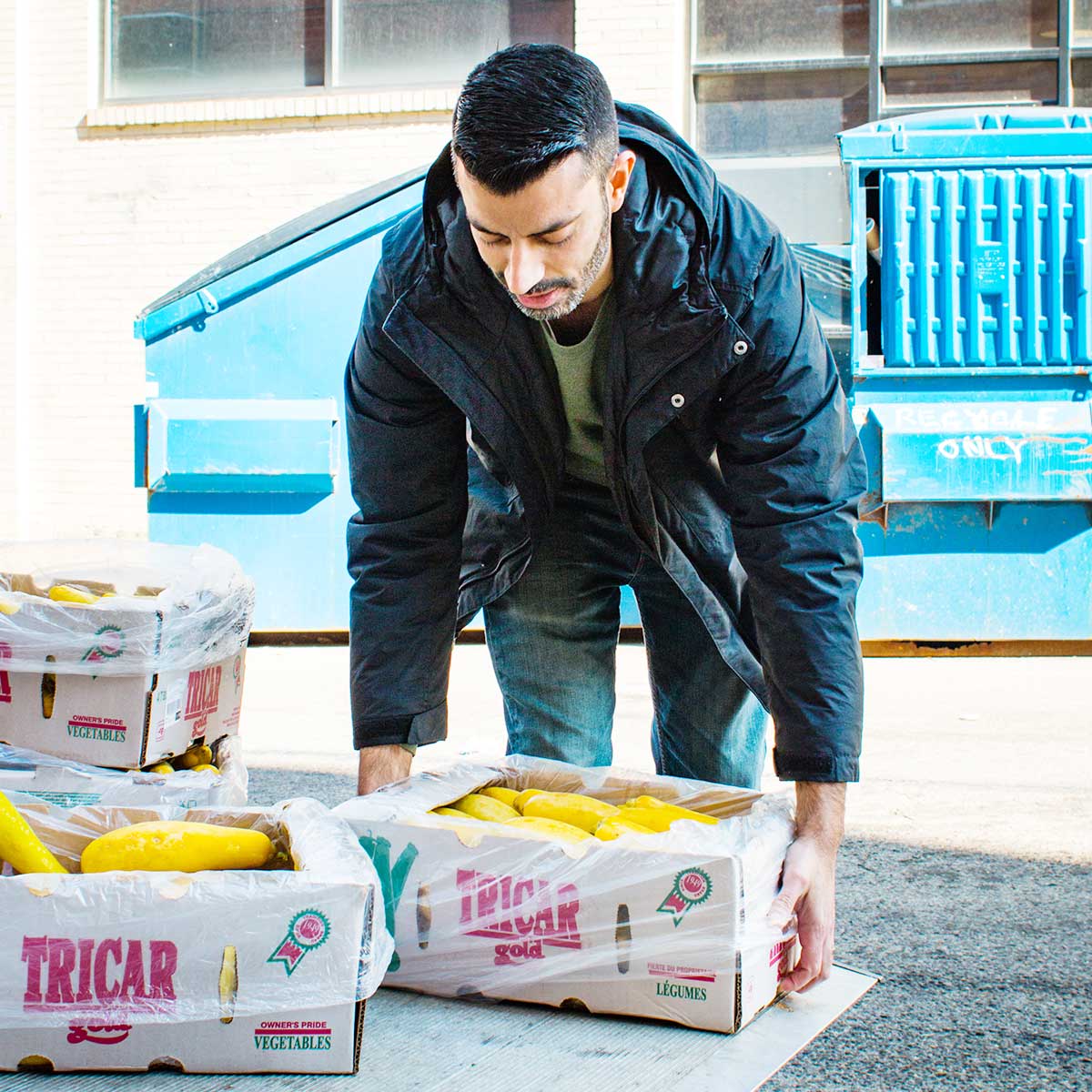 Man unloading boxes of squash