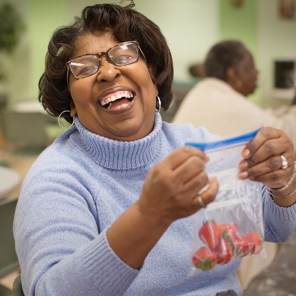 Woman laughing while packing strawberries