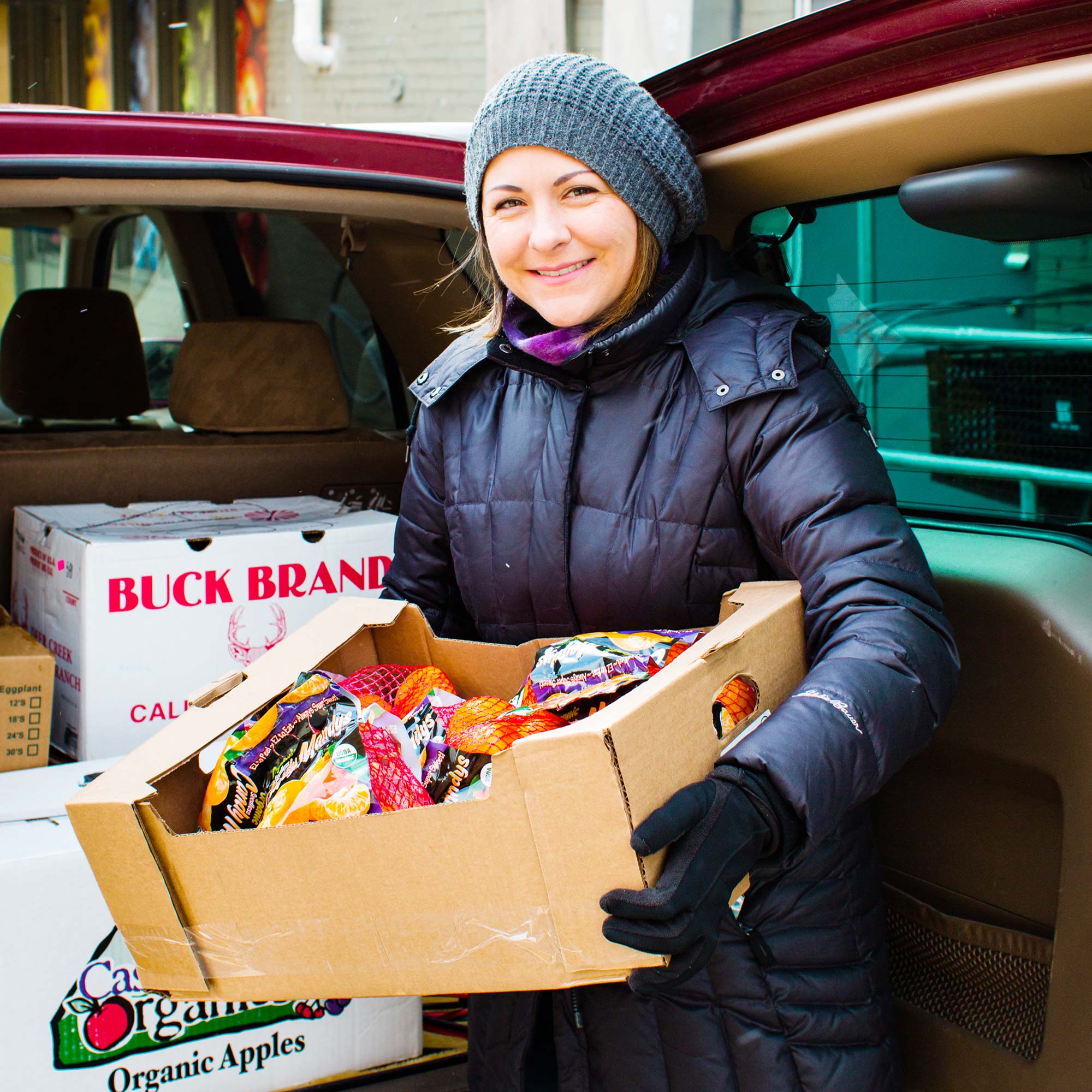 Woman unloading a box of rescued food from the back of her car